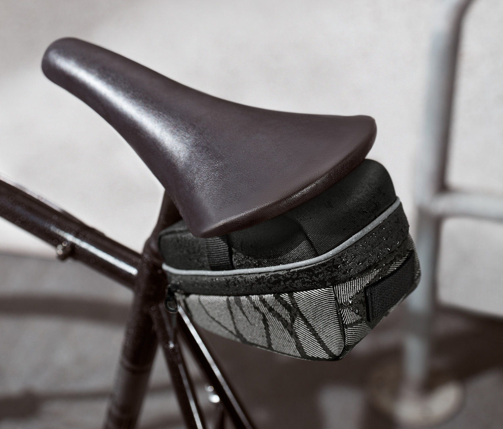 Czarna torba pod siodełkiem rowerowym przymocowana do roweru.