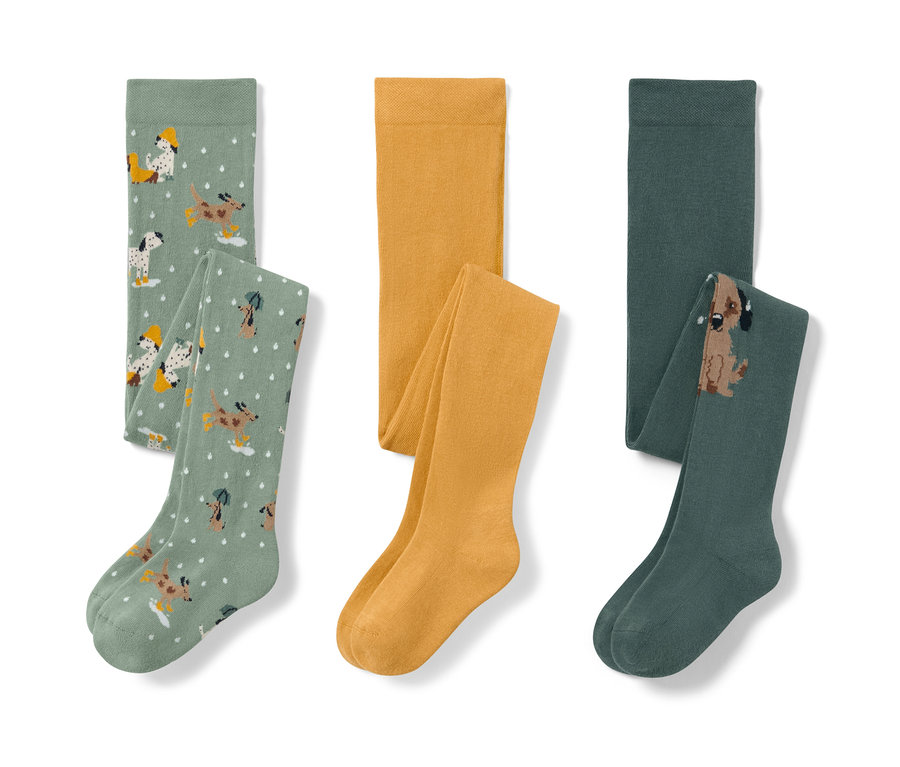 Trzy pary rajstop dziecięcych: jasnozielone we wzór z psami, żółte i ciemnozielone z psem.