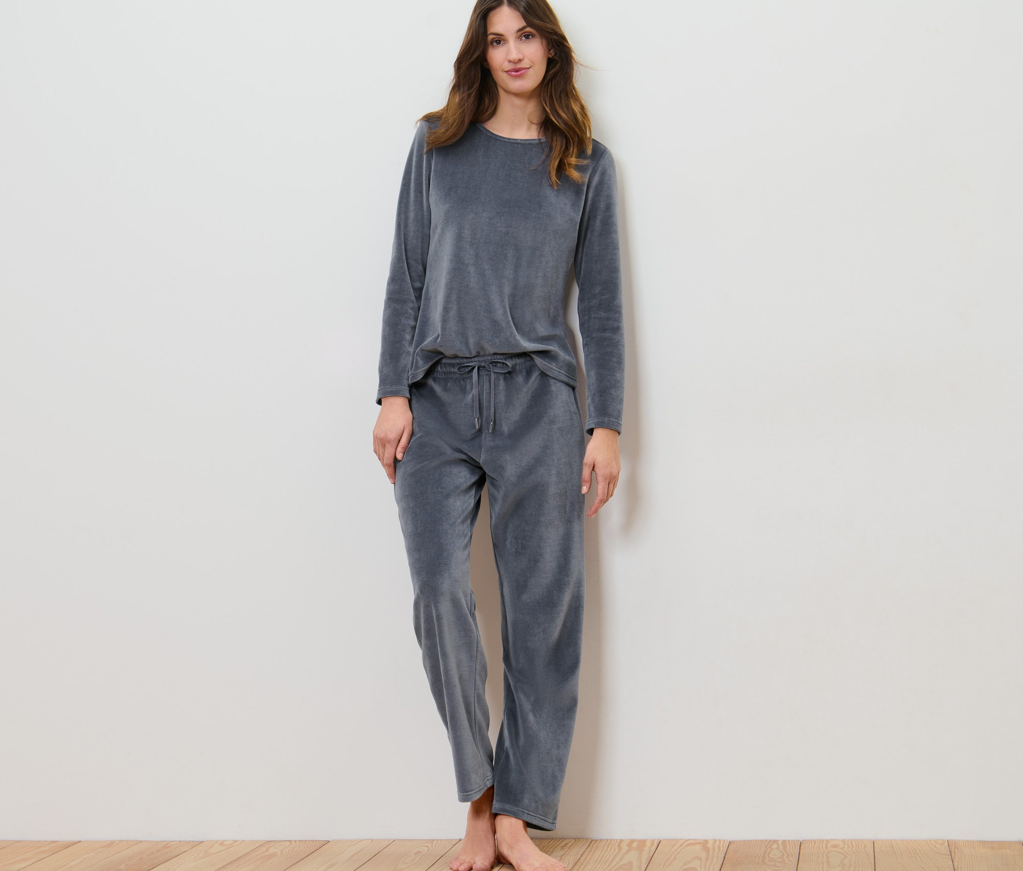 Kobieta stoi w piżamie z weluru.