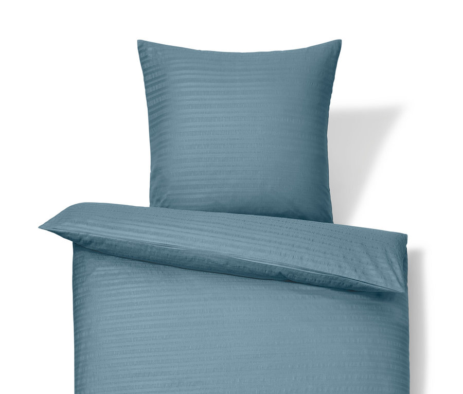 Niebieska pościel z kory w rozmiarze standardowym i niebieska pościel z kory w rozmiarze niestandardowym leżą na sobie.
