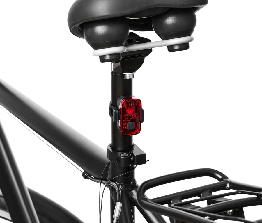 Szczegół tylnej części roweru z czerwonym światłem z zestawu lampek rowerowych.