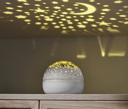 Projektor gwiazd LED wyświetla gwiazdy i księżyc na suficie.