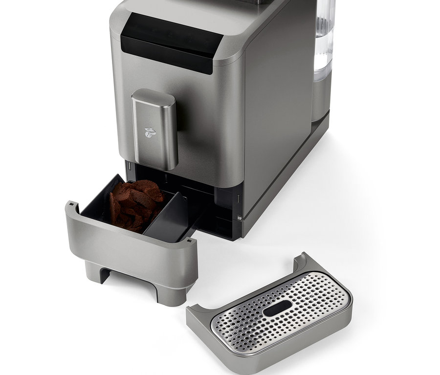 Szczegółowy widok automatycznego ekspresu do kawy »Esperto2 Caffè« w kolorze titanium silver z wyjętym pojemnikiem na fusy i tacką ociekową.