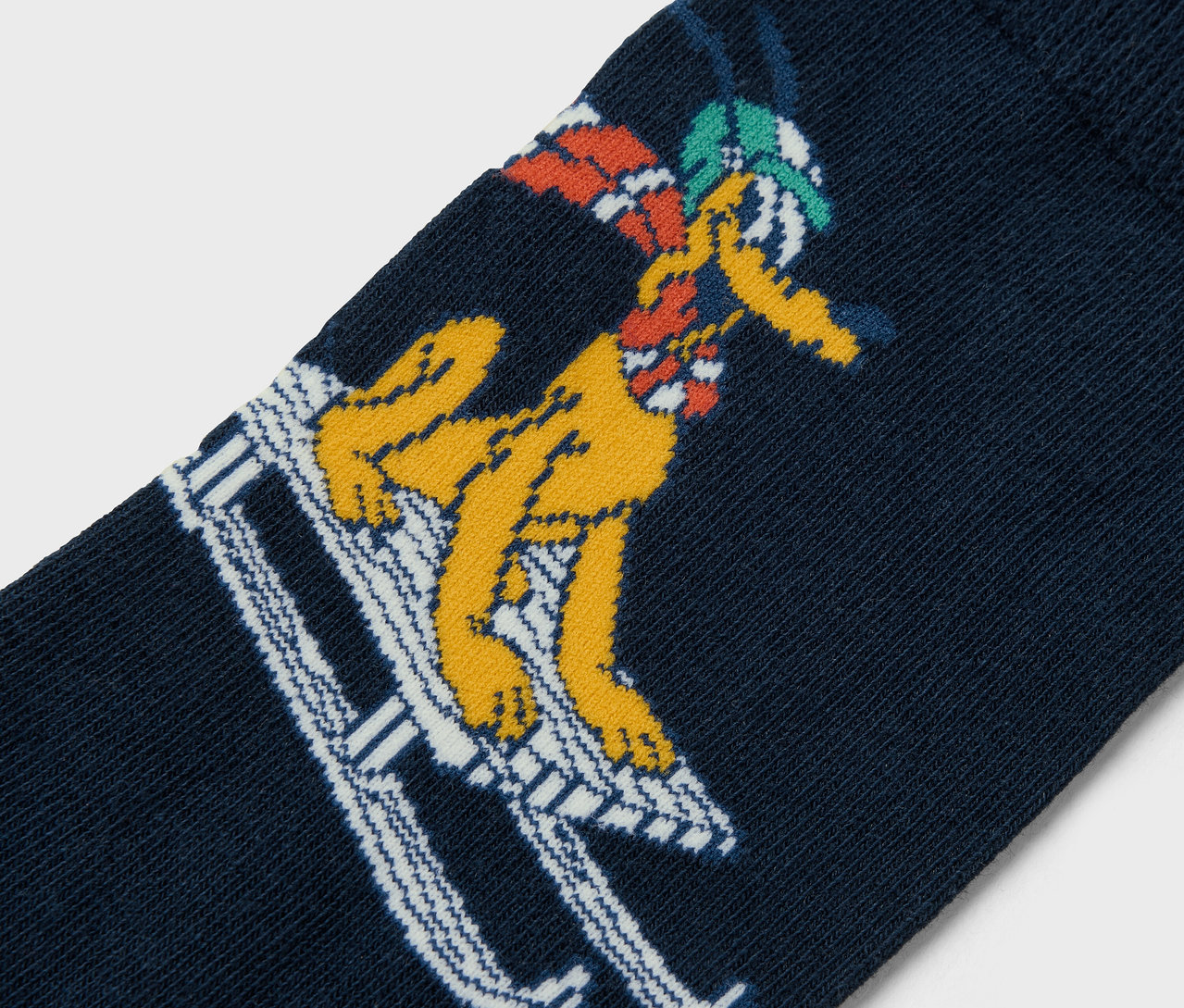 Zbliżenie granatowej skarpetki z żółtą postacią z kreskówki jeżdżącą na nartach.