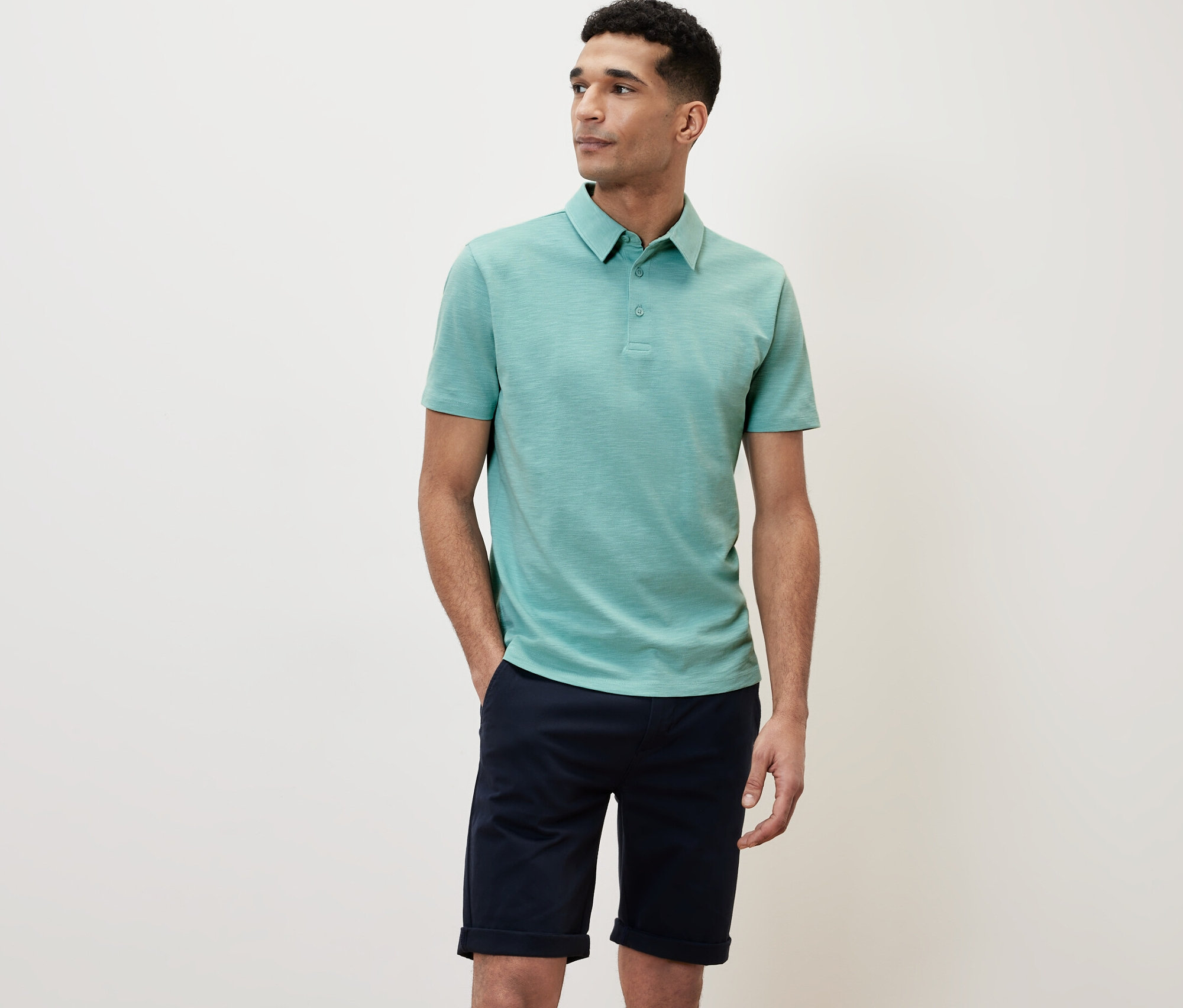 Mężczyzna w zielonej koszulce polo.