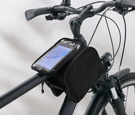 Czarna torba rowerowa z przezroczystym etui na telefon przymocowana do kierownicy roweru.