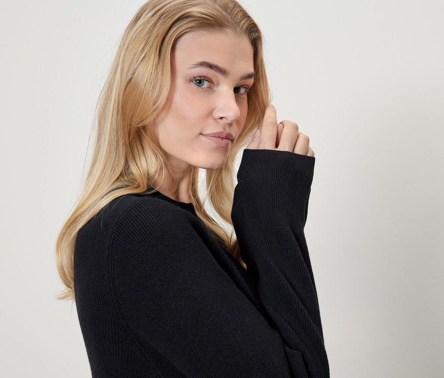 Portret blondynki w czarnym swetrze.