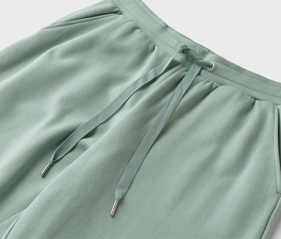 Zbliżenie na jasnozielone spodnie dresowe ze sznurkiem.