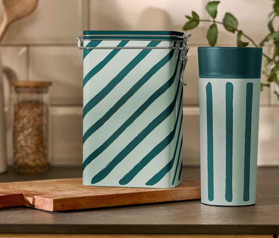 Na kuchennym stole stoją prążkowana puszka na kawę i kubek Coffee-to-go.