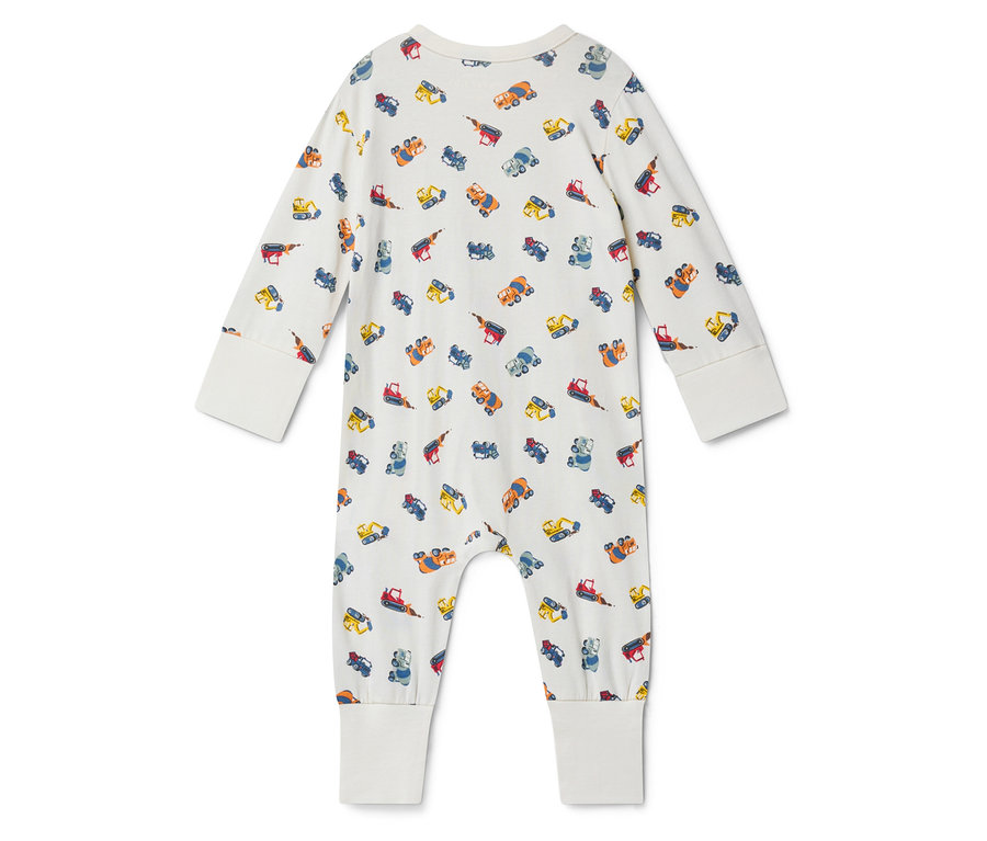 Widok z tyłu białego pajacyka niemowlęcego z długimi rękawami, pokrytego nadrukiem z małych, kolorowych samochodów budowlanych.