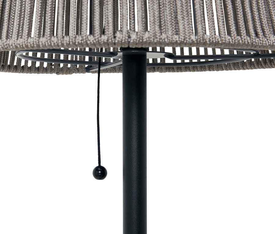 Zbliżenie szarej lampy podłogowej z czarną podstawą i sznurkowym włącznikiem.