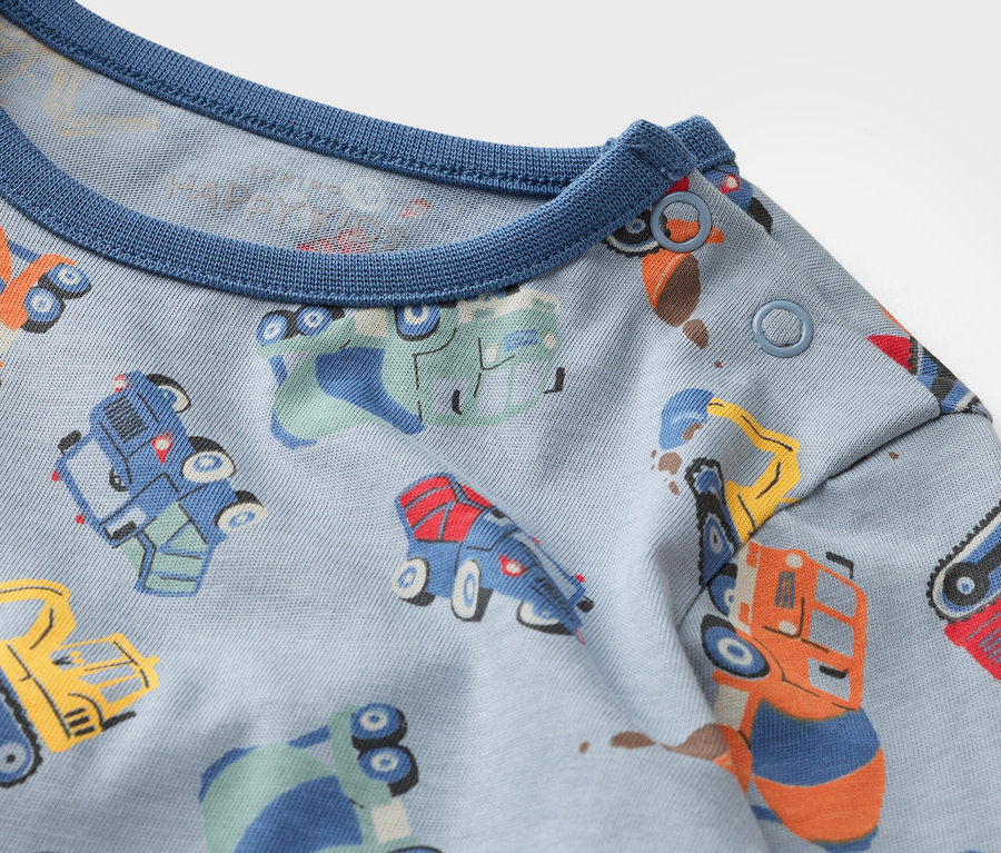 Zbliżenie na jasnoniebieski materiał z wielokolorowymi pojazdami.