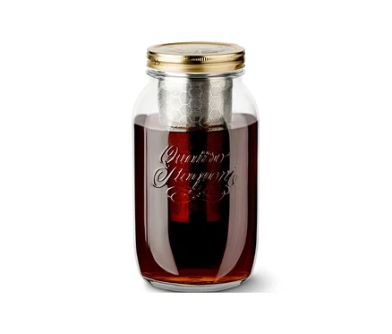 Słoik z zaparzaczem na zimno »BrewJar« wypełniony napojem na białym tle.