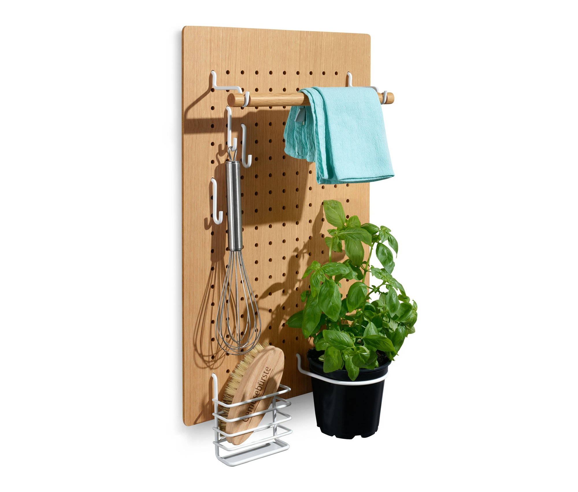 Drewniany organizer ścienny z haczykami, na których wiszą: ściereczka, trzepaczka, szczotka i doniczka z kwiatem.