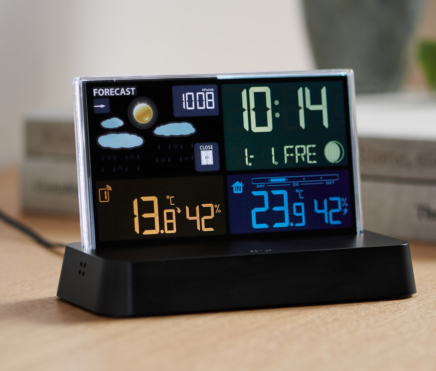 Czarna radiowa stacja pogodowa z kolorowym wyświetlaczem LCD pokazuje godzinę 10:14, temperatury 13,8°C i 23,9°C oraz prognozę pogody.