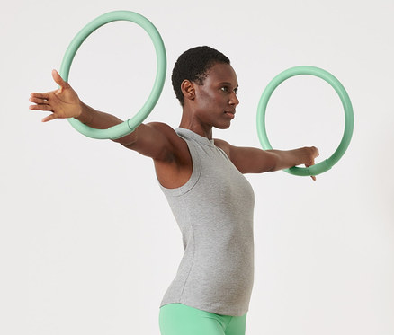 Kobieta ćwiczy z 2 obręczami do ćwiczeń ramion.