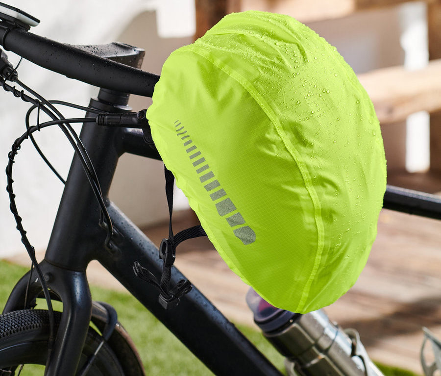 Neonowy żółty pokrowiec na kask rowerowy na rowerze.