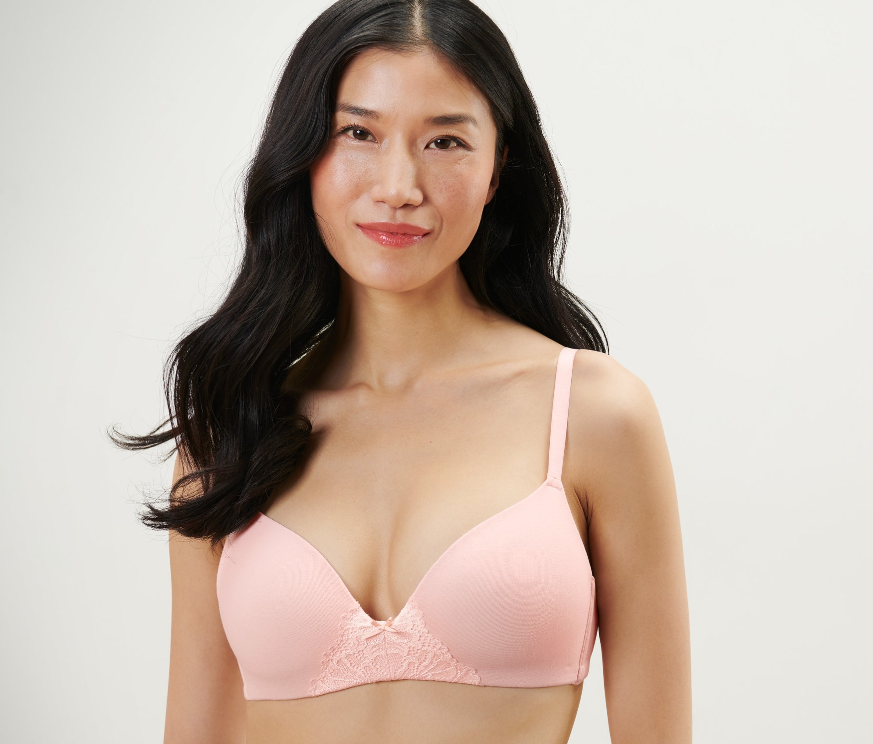 Kobieta ma na sobie bladoróżowy biustonosz z miękkimi miseczkami.