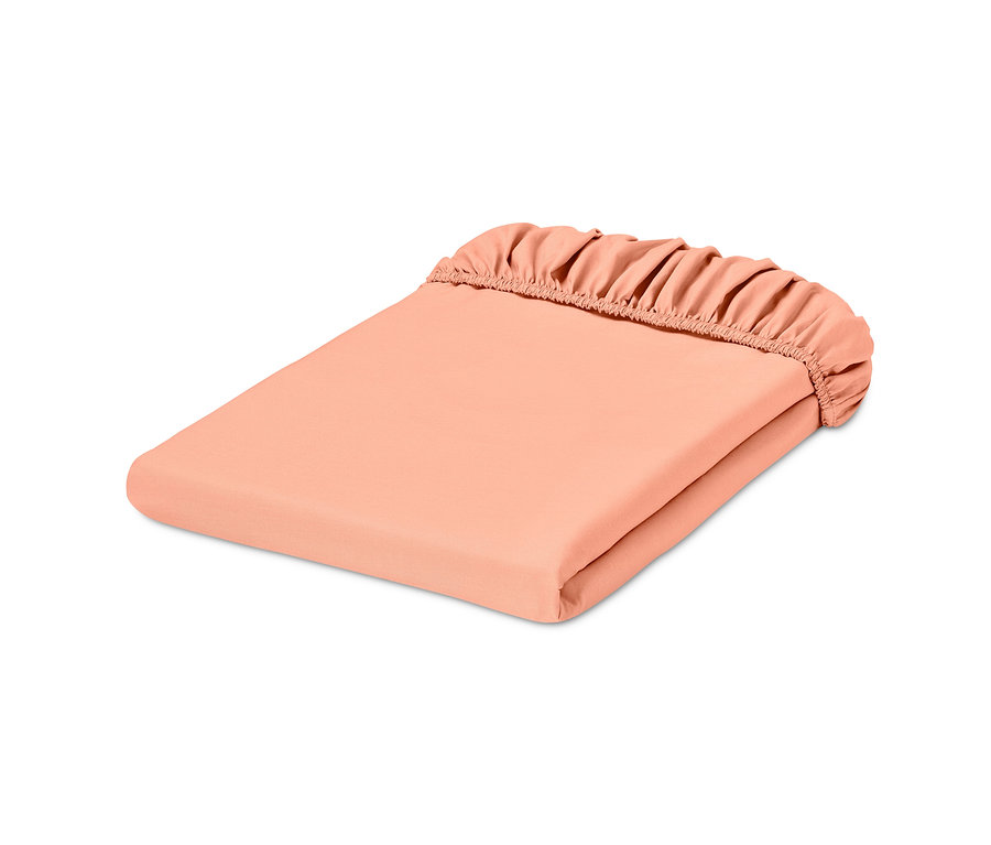 Złożone morelowe perkalowe prześcieradło z gumką w standardowym rozmiarze.