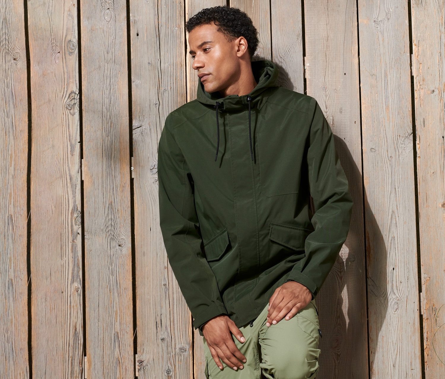 Mężczyzna oparty o drewnianą ścianę w parce funkcyjnej.