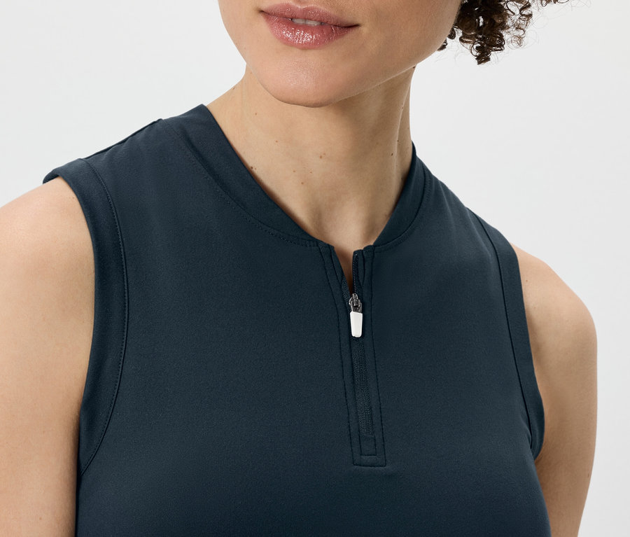 Kobieta ma na sobie granatowy top funkcyjny.