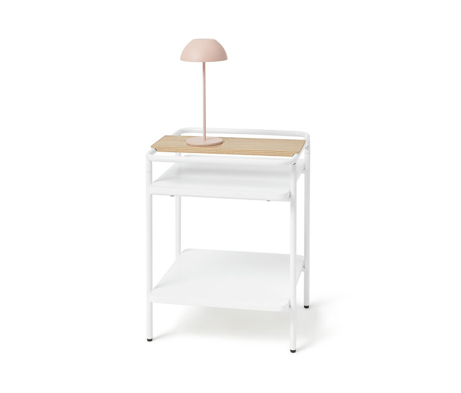 Biały stolik z jasną drewnianą powierzchnią i różową lampą.
