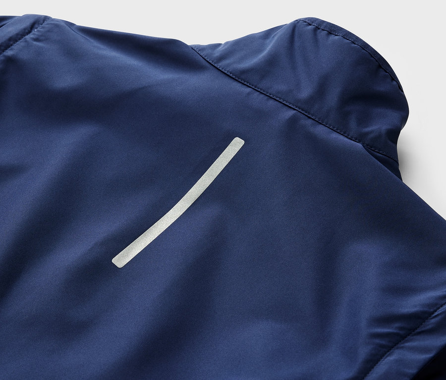 Zbliżenie na granatową kurtkę rowerową 2 w 1 z odblaskowym paskiem.