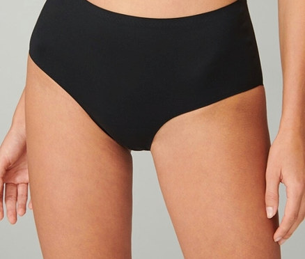 Zbliżenie kobiety w czarnych majtkach bikini z wysokim stanem.