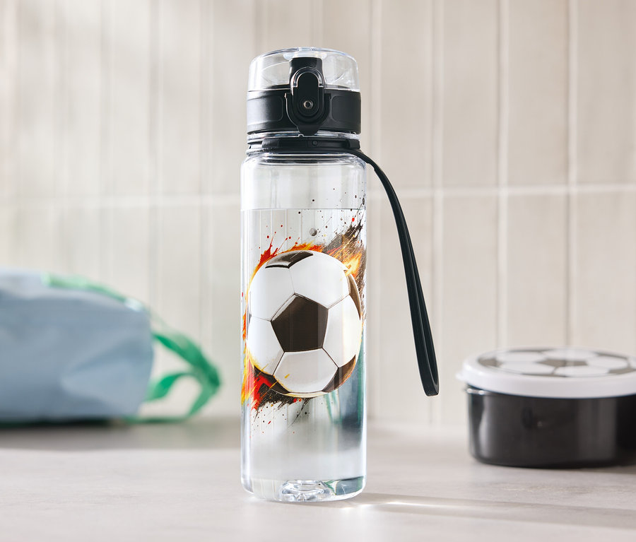 Butelka na wodę z motywem piłki nożnej stoi na stole.