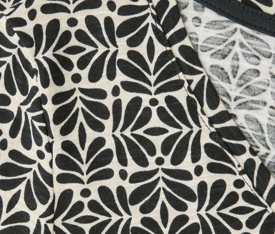 Zbliżenie na koszulkę Street One z czarnym wzorem liści i kropek oraz dekoltem w serek.