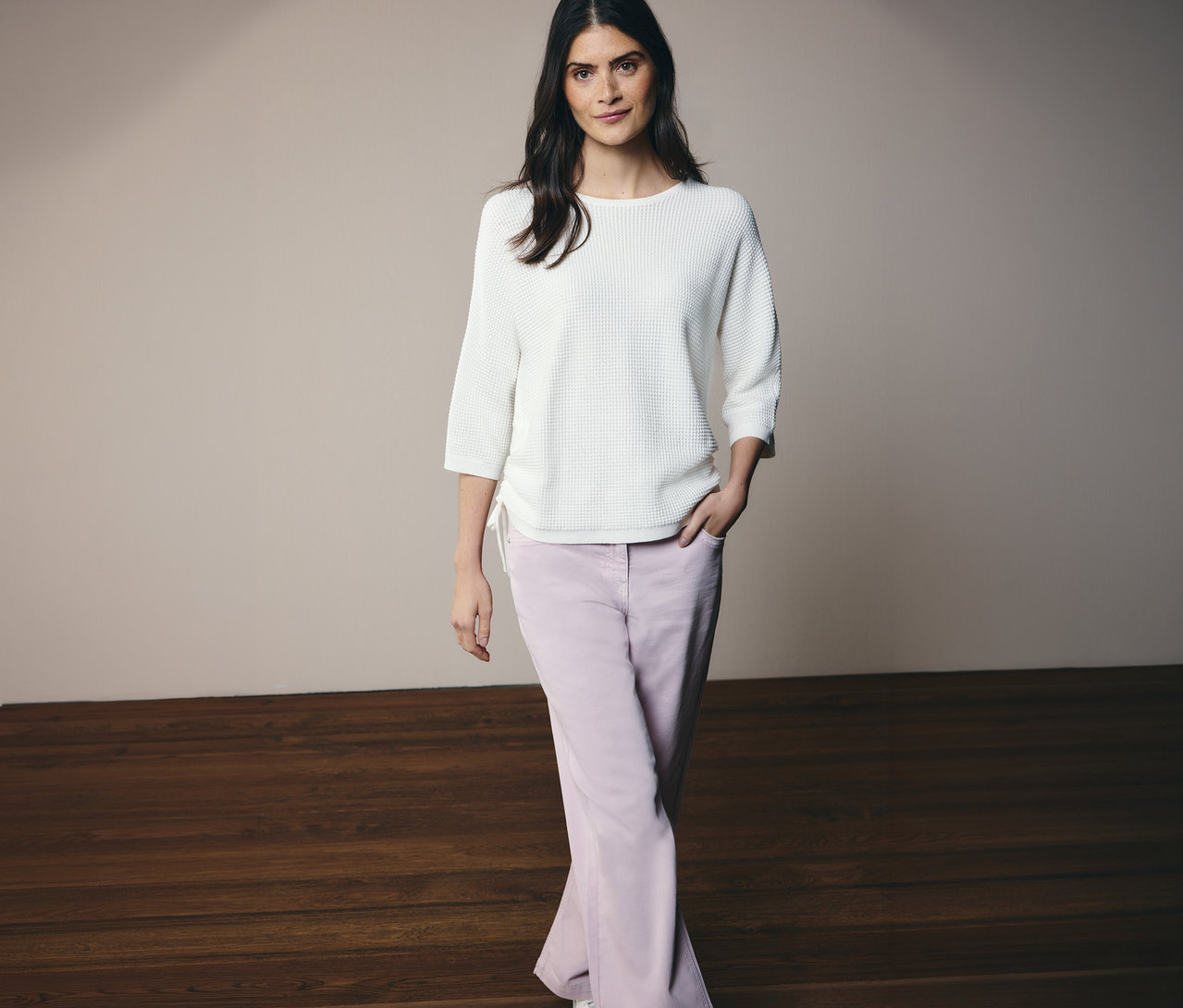 Kobieta pozuje w cienkim swetrze CECIL i dżinsach CECIL „Neele”.