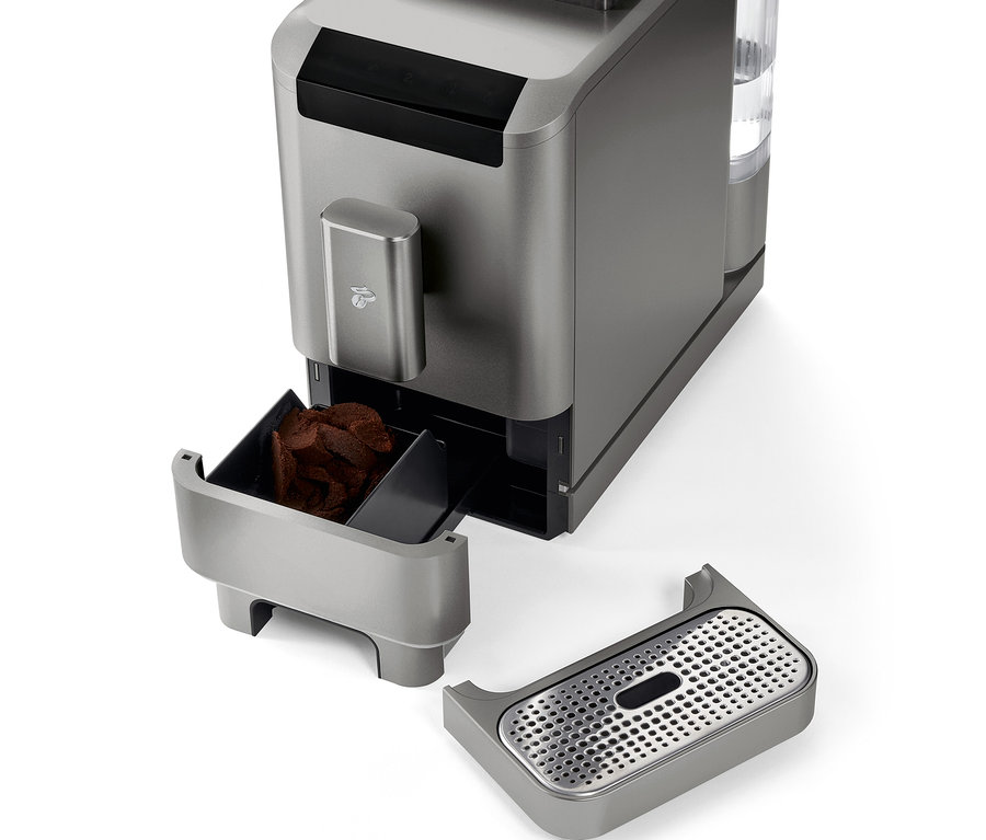 Szczegółowy widok automatycznego ekspresu do kawy »Esperto2 Caffè« w kolorze titanium silver z wyjętym pojemnikiem na fusy i tacką ociekową.