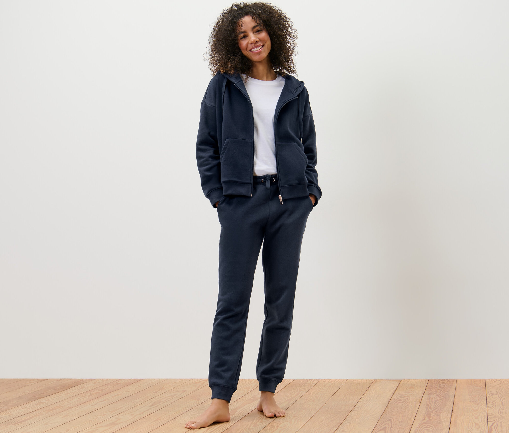 Kobieta ma na sobie granatowy dres domowy.