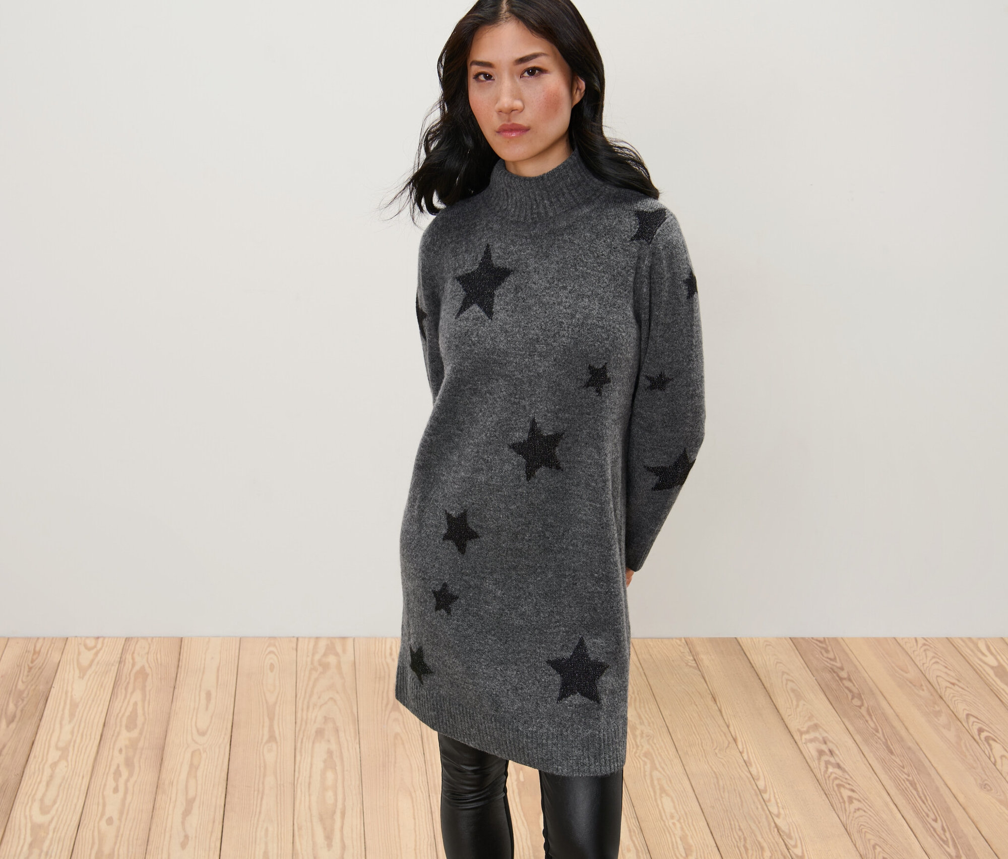 Kobieta pozuje w sukience z dzianiny z golfem.