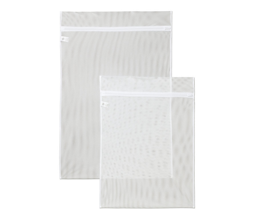 Dwie białe siatki do prania w różnych rozmiarach leżą na sobie.