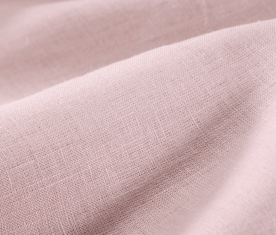 Zbliżenie na bladoróżową pościel lnianą w rozmiarach standardowych i niestandardowych.
