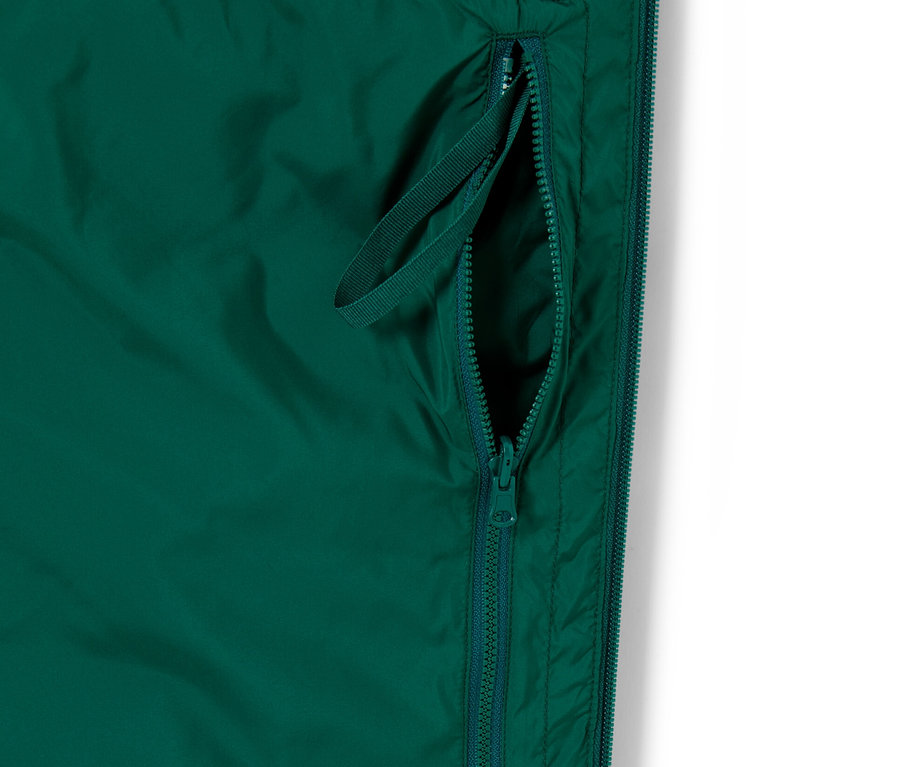 Szczegół zielonej, pikowanej kamizelki Zwijana pikowana kamizelka zapinana na zamek błyskawiczny ze szlufką.