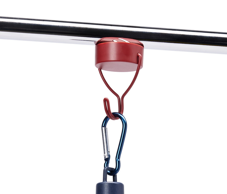 Niebieska lampa wisi na metalowym pręcie na 3 haczykach magnetycznych.