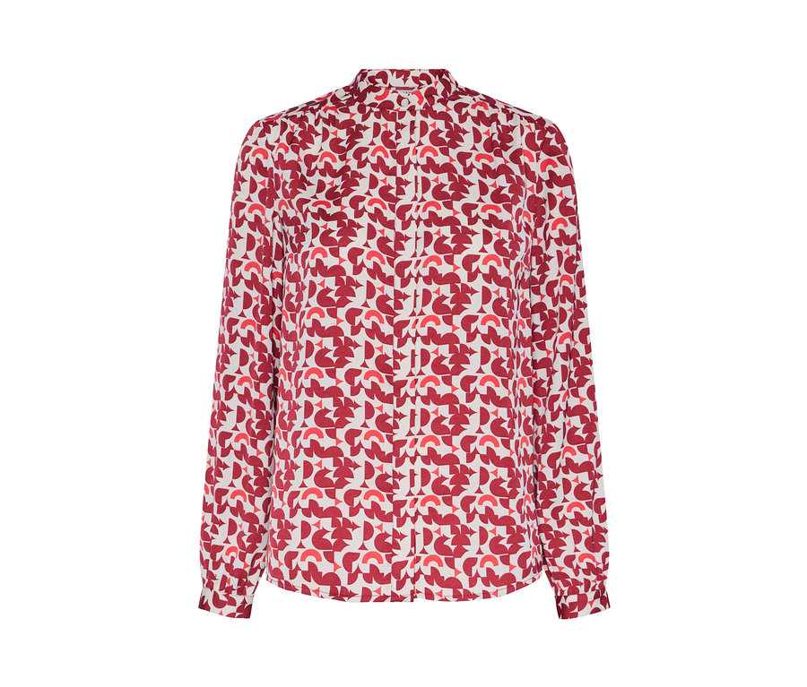 Detal bluzki z nadrukiem w czerwone geometryczne wzory.