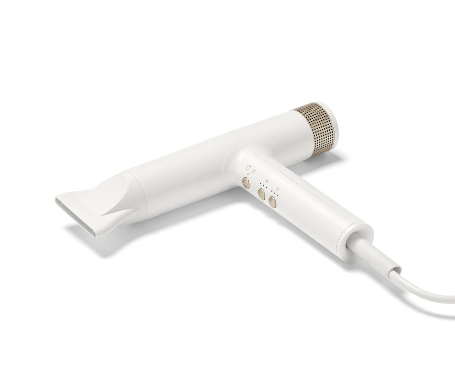 Biała profesjonalna suszarka do włosów z nową technologią suszenia leży na białym tle.