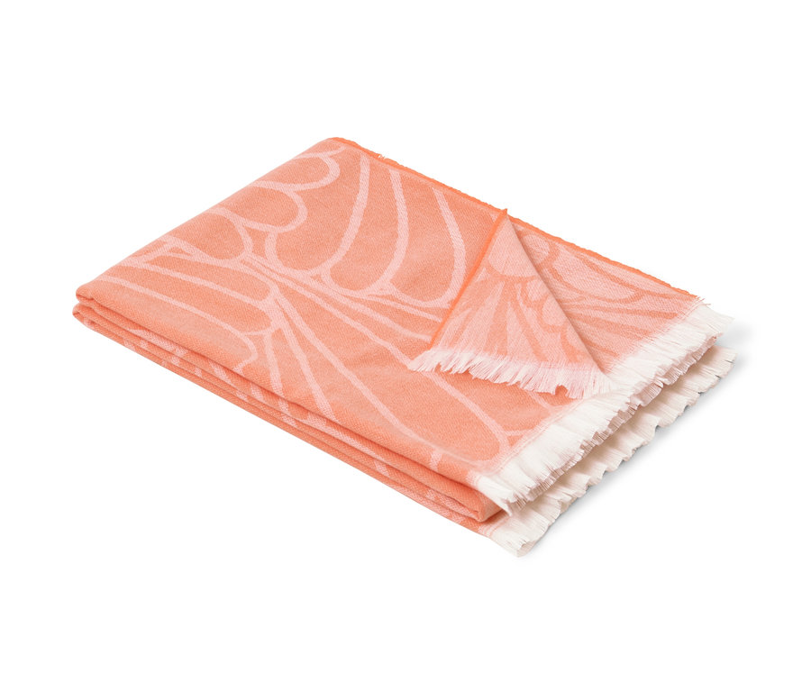 Złożona dwustronna narzuta z frędzlami w kwiatowy wzór w kolorze pomarańczowym.