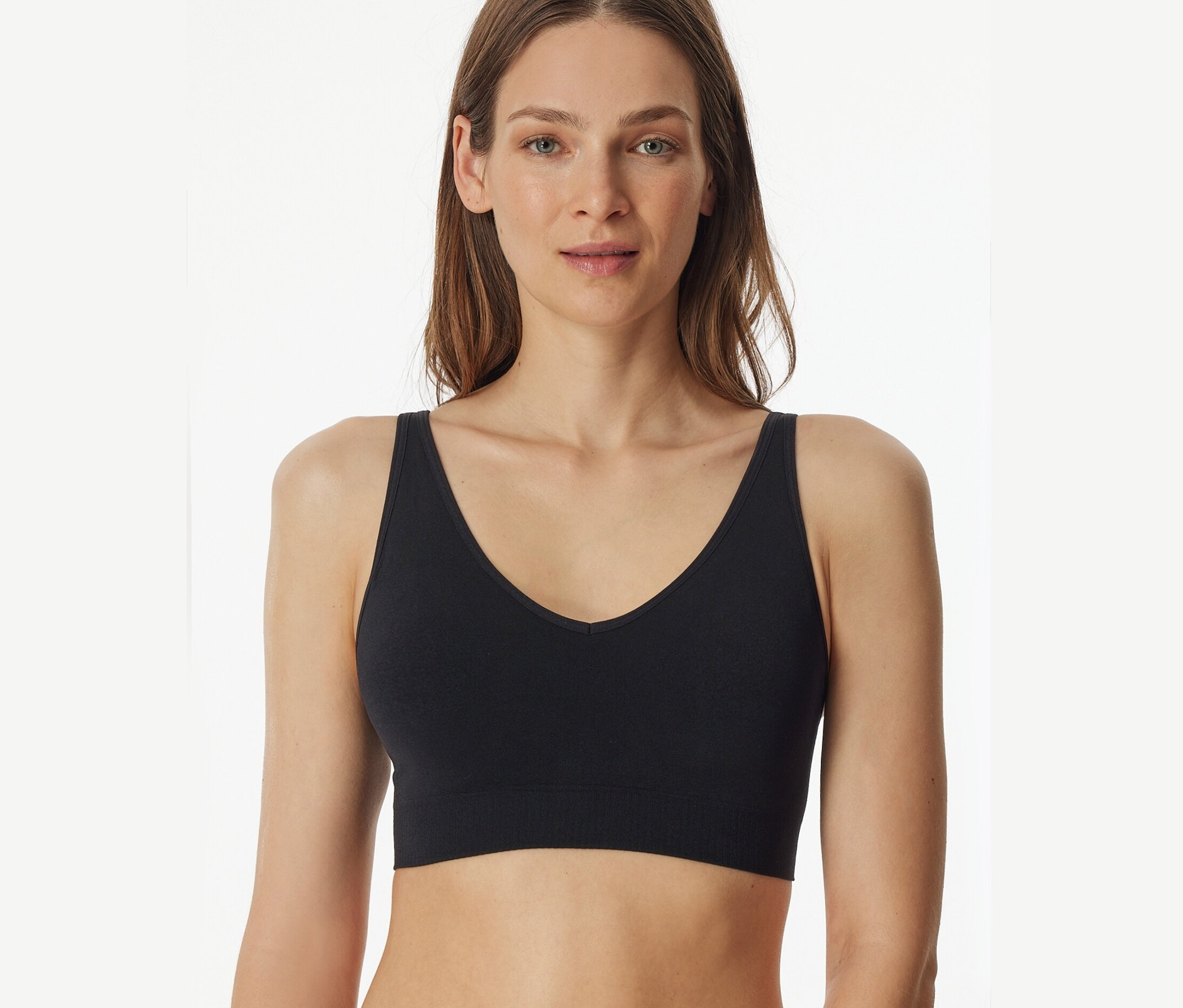 Kobieta ma na sobie czarny biustonosz z wkładkami SCHIESSER.