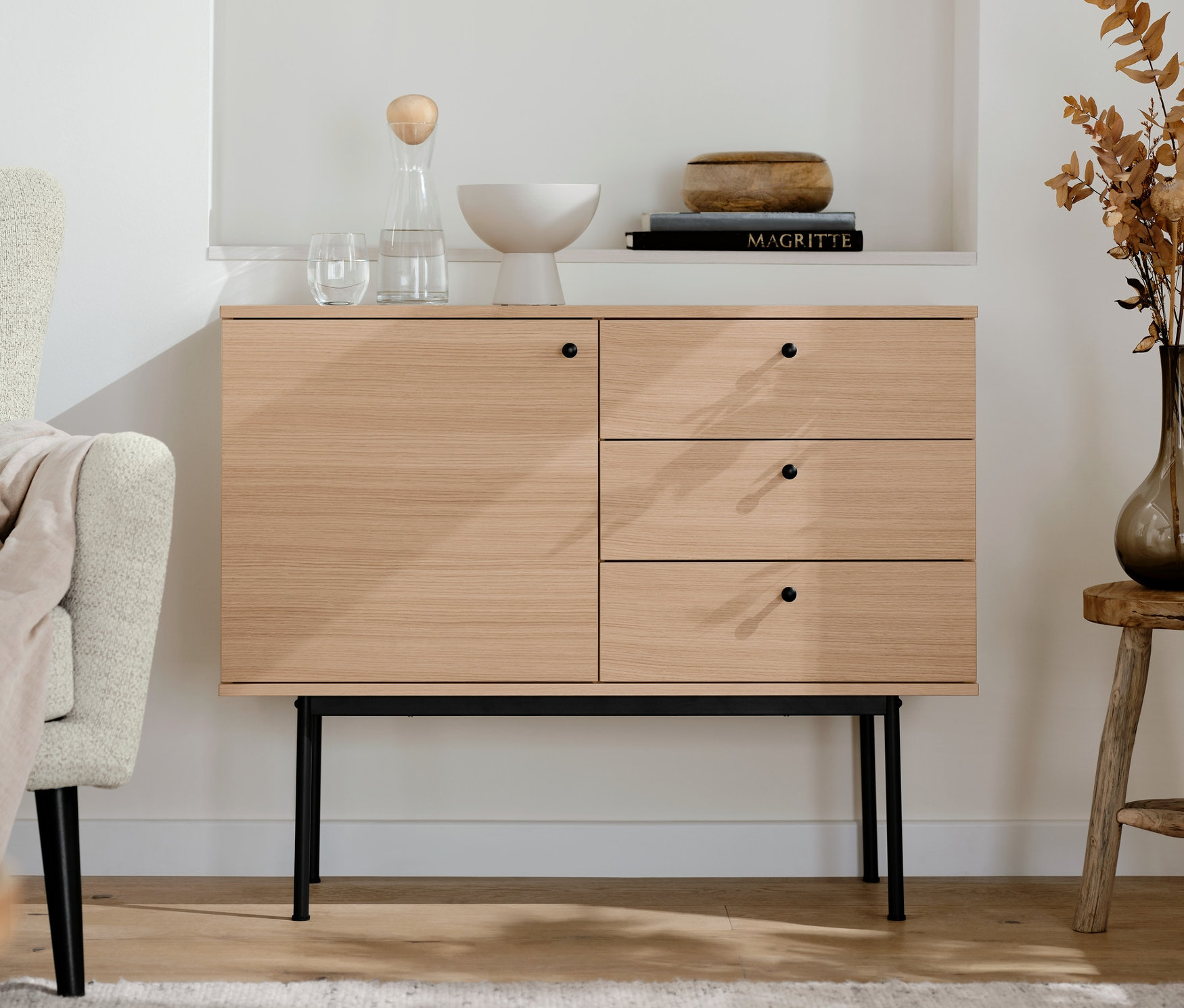 W salonie stoi konsola z szufladami »Finnsbo«. Nad nią znajdują się półki z dekoracjami.