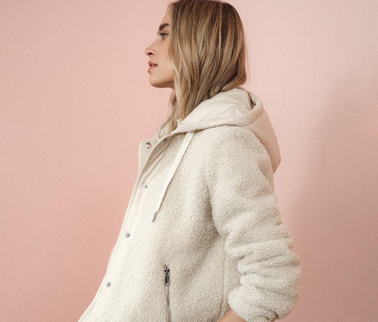 Kobieta z profilu ma na sobie bluzę pluszową z odpinanym kapturem Street One.