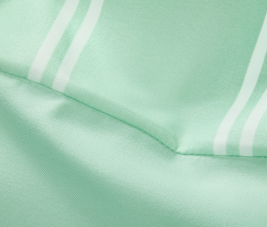 Zbliżenie jasnozielonej tkaniny z białymi paskami.