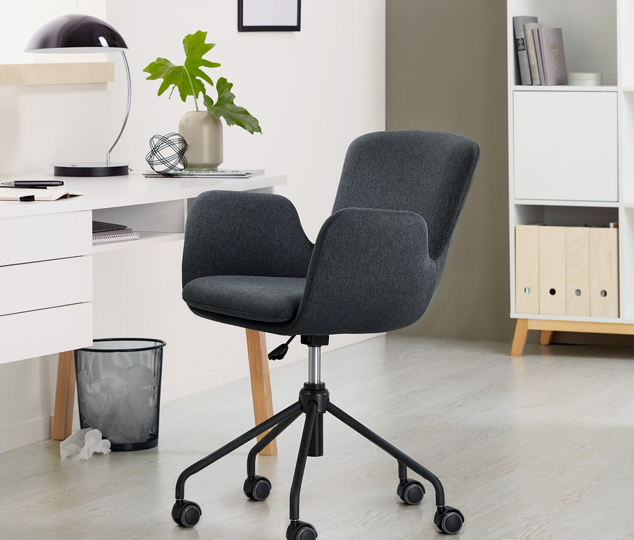 Antracytowe krzesło do biurka stoi w pokoju.