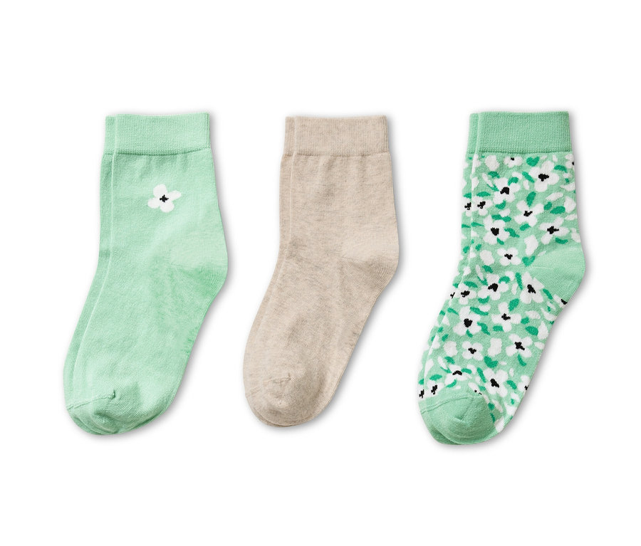 Trzy pary skarpetek: jedna para jasnozielona z białym kwiatem, jedna para beżowa i jedna para jasnozielona we wzory kwiatowe.
