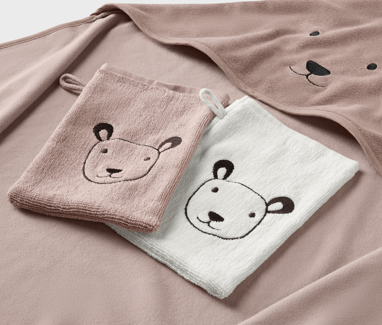 Dziecięcy ręcznik z kapturem i dwie myjki z haftem przedstawiającym twarz misia.