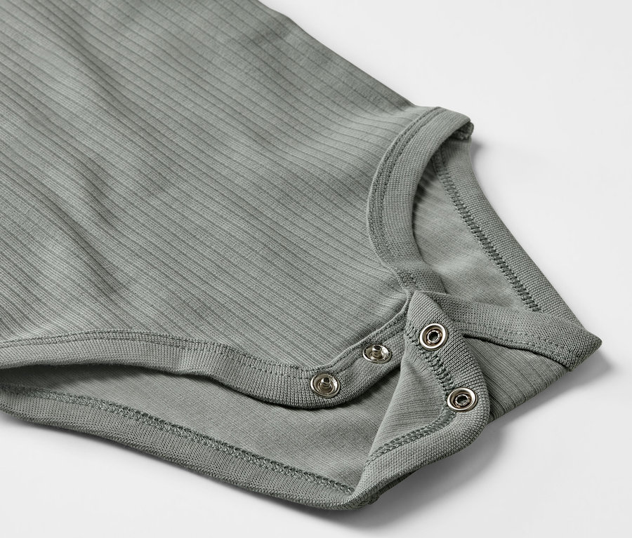 Zbliżenie na szare body z długim rękawem dla niemowląt, zapinane na zatrzaski.