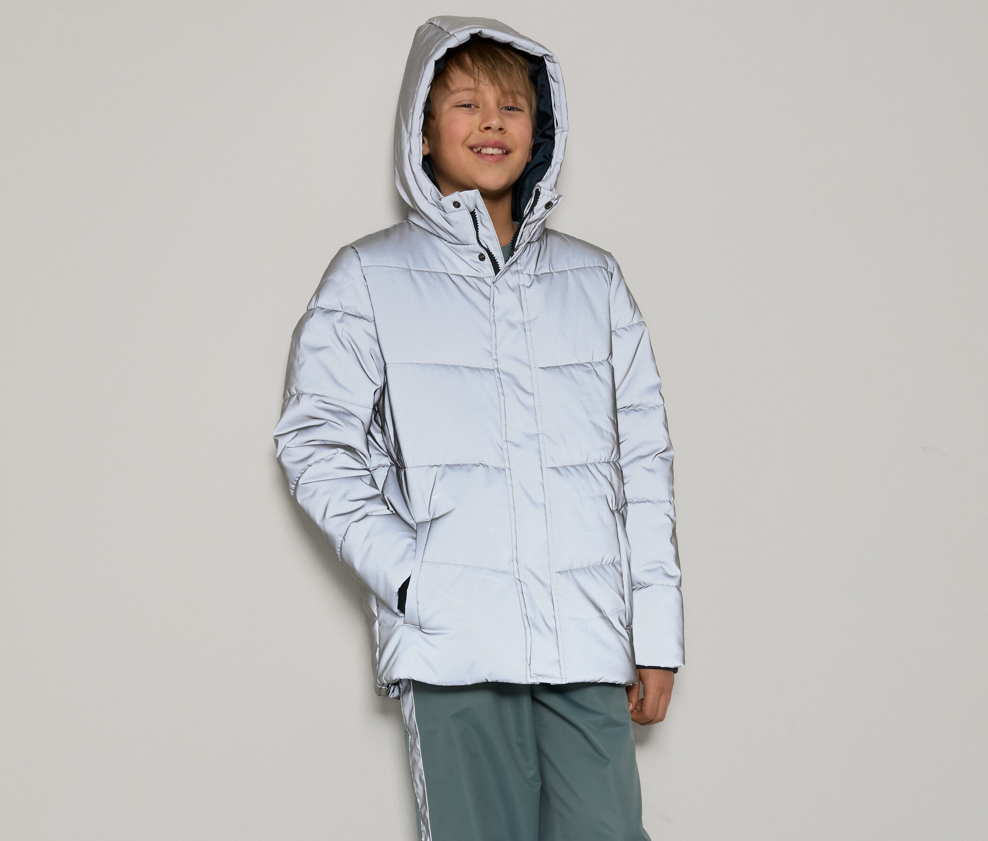 Chłopiec ma na sobie odblaskową kurtkę puchową dla dzieci.